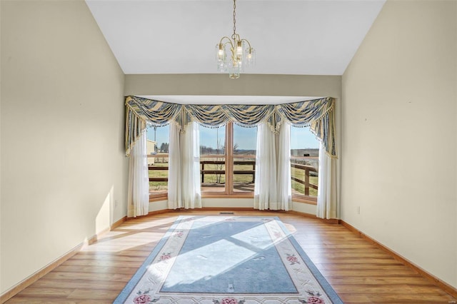 doorway with light wood-style flooring, plenty of natural light, and a chandelier