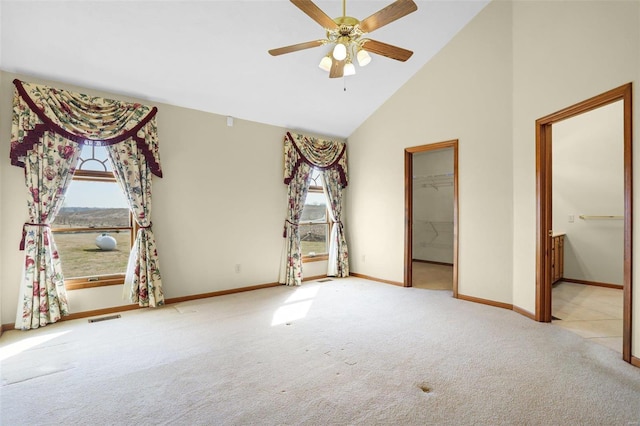 empty room featuring visible vents, baseboards, ceiling fan, carpet flooring, and high vaulted ceiling