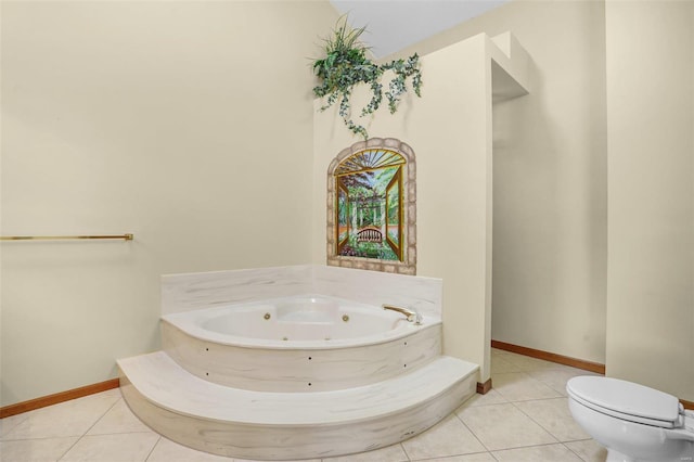 bathroom featuring tile patterned floors, toilet, baseboards, and a whirlpool tub