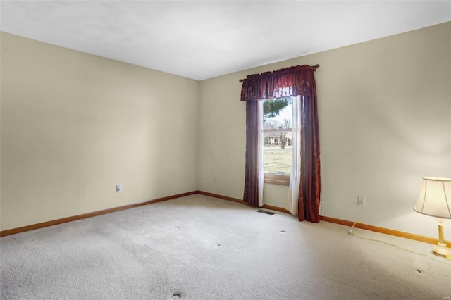 empty room with carpet flooring, baseboards, and visible vents