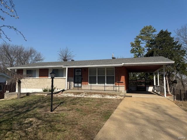 ranch-style home featuring a carport, concrete driveway, brick siding, and fence