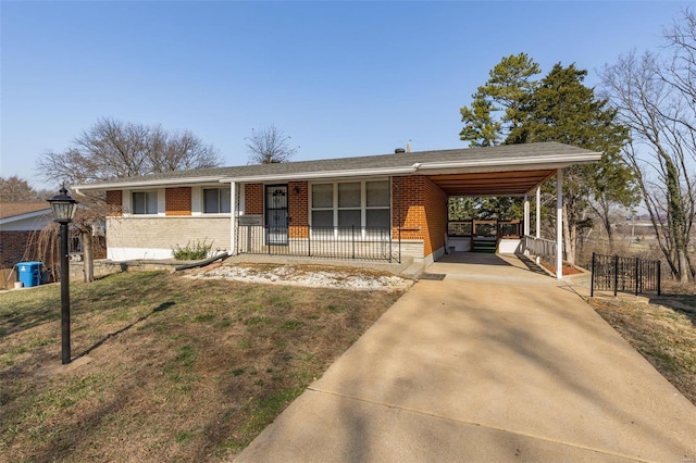 ranch-style house with an attached carport, brick siding, and concrete driveway