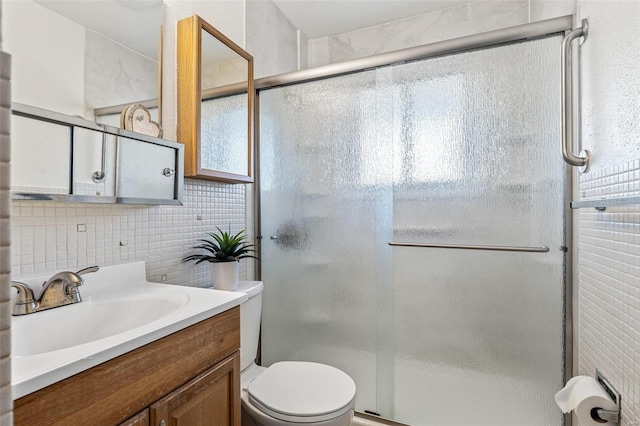 bathroom with decorative backsplash, a stall shower, toilet, and vanity