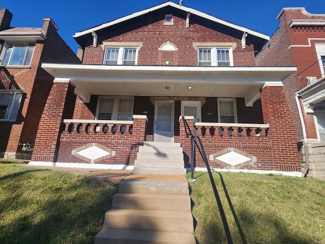 view of front of home featuring brick siding and covered porch