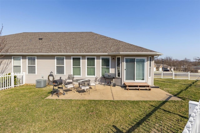 back of house with a patio area, a lawn, a fenced backyard, and roof with shingles