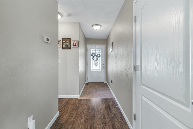 doorway with baseboards and wood finished floors