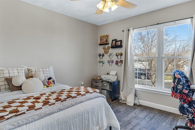 bedroom with baseboards, wood finished floors, and a ceiling fan