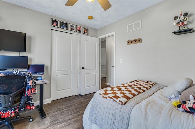 bedroom featuring a ceiling fan, wood finished floors, visible vents, baseboards, and a closet