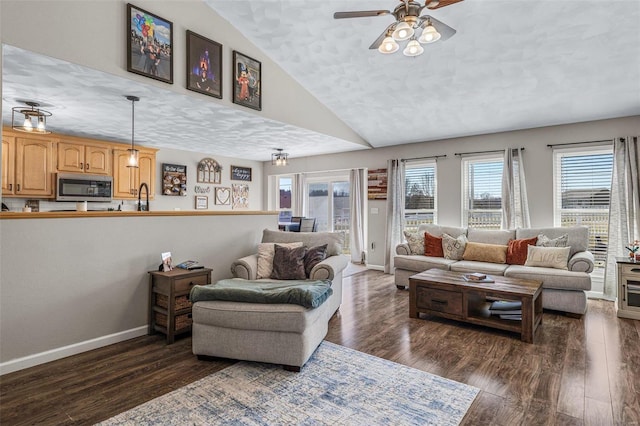 living area featuring dark wood finished floors, lofted ceiling, and a ceiling fan