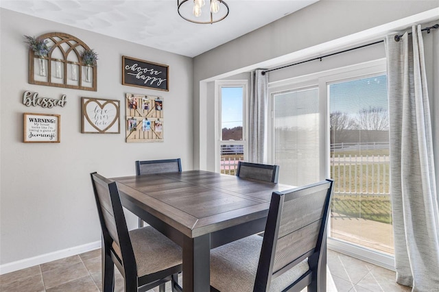 dining room featuring light tile patterned floors, an inviting chandelier, and baseboards