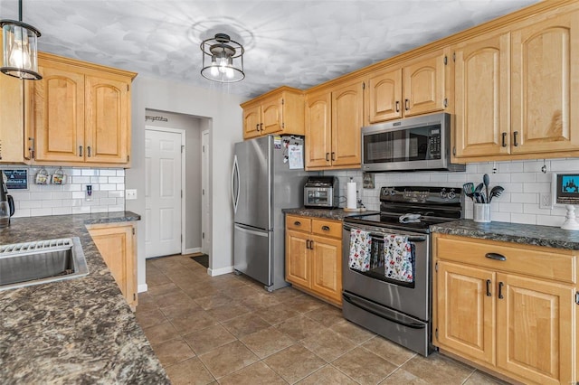 kitchen with baseboards, light brown cabinetry, appliances with stainless steel finishes, decorative light fixtures, and backsplash