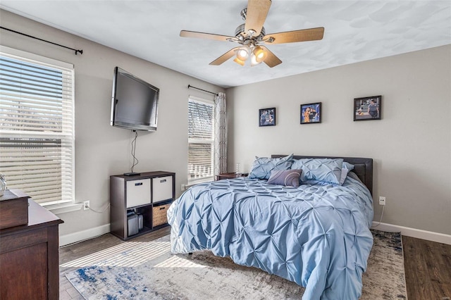 bedroom featuring wood finished floors, baseboards, and ceiling fan