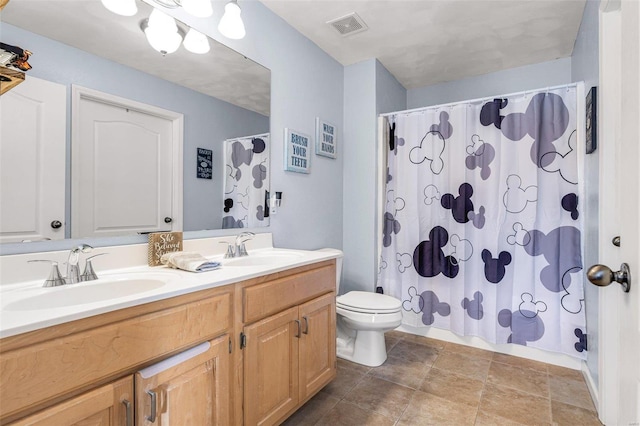 full bath featuring double vanity, toilet, visible vents, and a sink