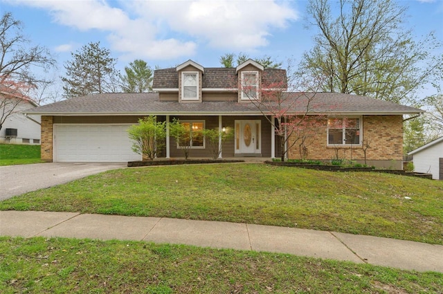 traditional-style house with an attached garage, asphalt driveway, a front lawn, and brick siding