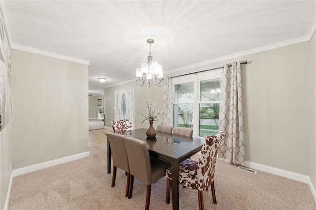 dining space featuring ornamental molding, a chandelier, light carpet, and baseboards