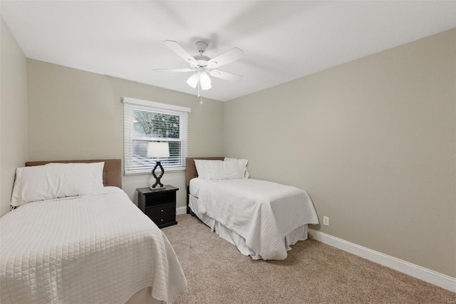 bedroom featuring light carpet, baseboards, and ceiling fan