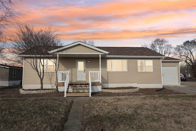 view of front of property with covered porch, a front yard, a garage, and roof with shingles