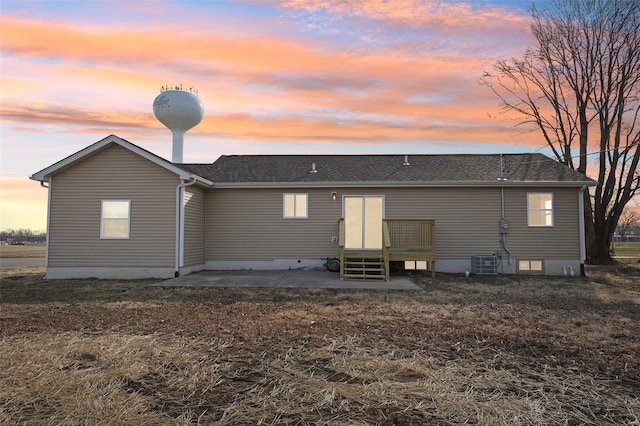 back of house with a patio area, entry steps, central AC, and roof with shingles