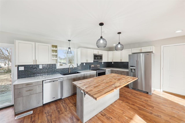 kitchen with a healthy amount of sunlight, stainless steel appliances, wood counters, and a sink