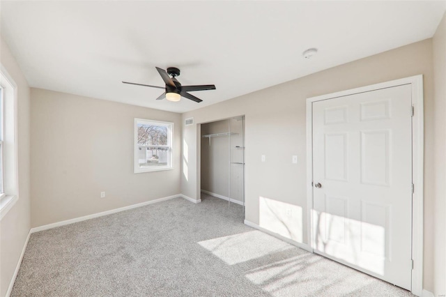 unfurnished bedroom featuring visible vents, a closet, carpet floors, baseboards, and ceiling fan