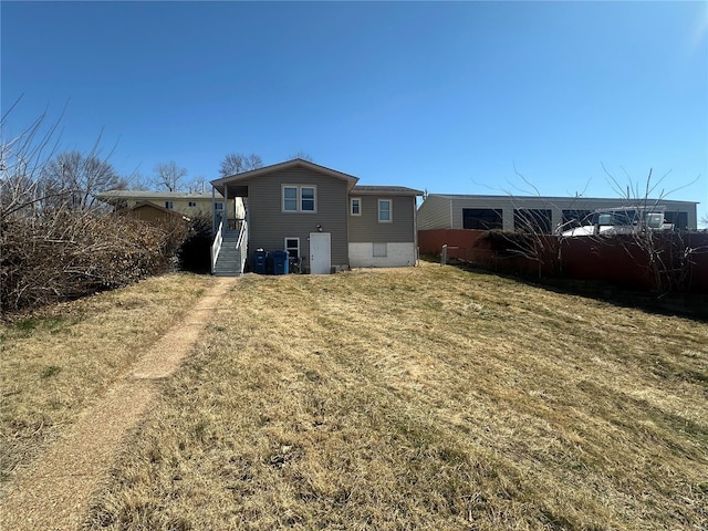 back of property featuring a yard and fence