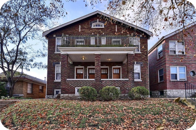 view of front of house featuring a balcony, covered porch, and brick siding