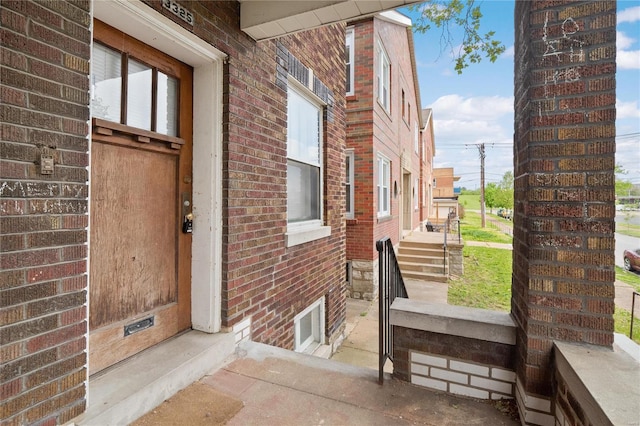 view of exterior entry featuring brick siding