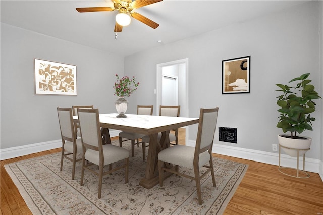 dining area featuring baseboards, light wood finished floors, and ceiling fan