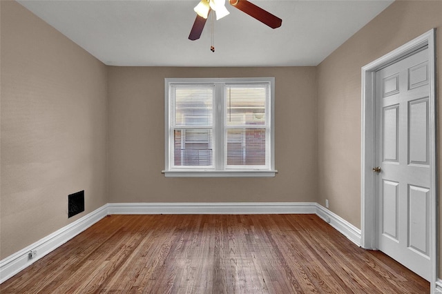 unfurnished room featuring ceiling fan, baseboards, and wood finished floors