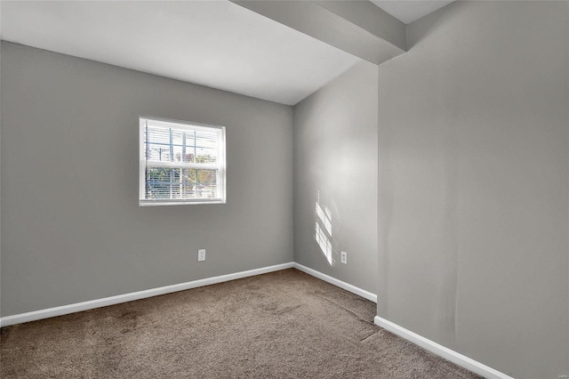 carpeted spare room featuring baseboards