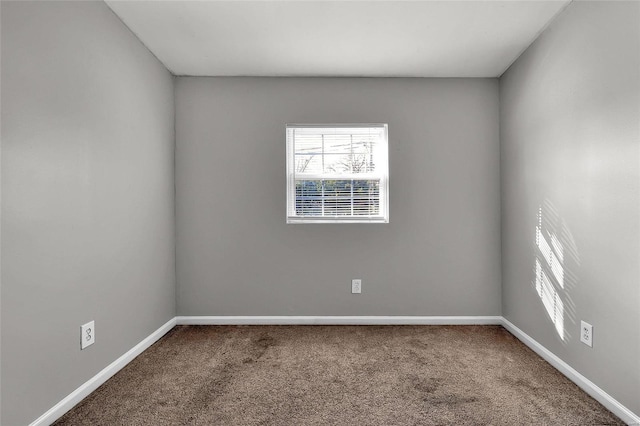 carpeted spare room featuring baseboards