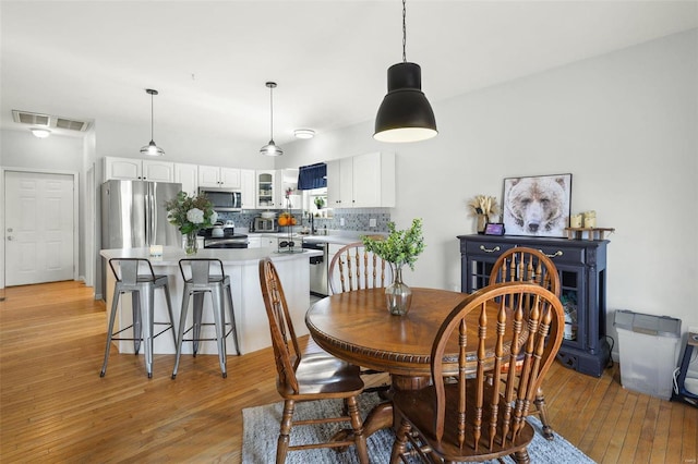 dining area featuring visible vents and light wood-style floors