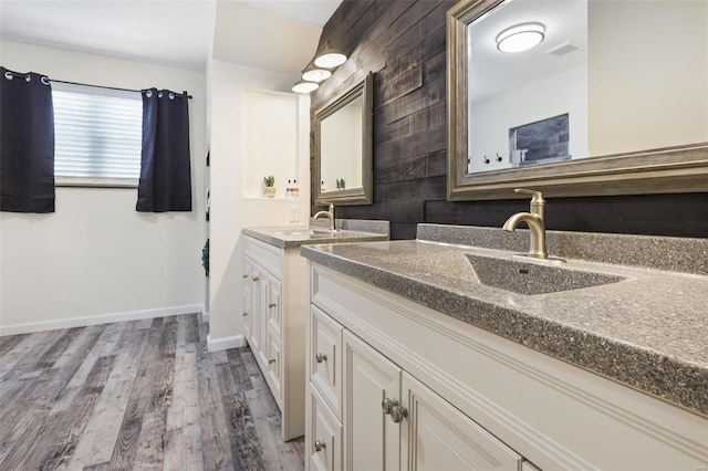 full bathroom with baseboards, wood finished floors, and vanity