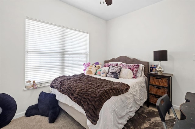 carpeted bedroom featuring baseboards and a ceiling fan