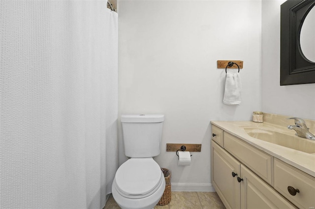 bathroom featuring baseboards, toilet, vanity, and tile patterned flooring