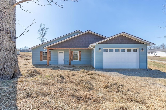 view of front facade with gravel driveway and an attached garage