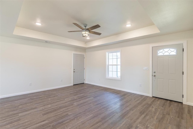 entryway featuring baseboards, a raised ceiling, and wood finished floors