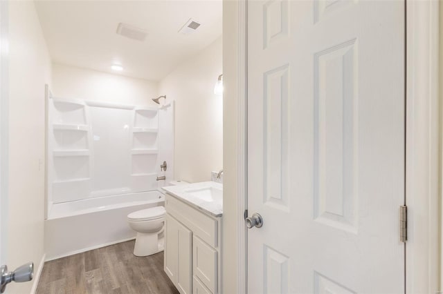 bathroom featuring vanity, wood finished floors, visible vents, tub / shower combination, and toilet