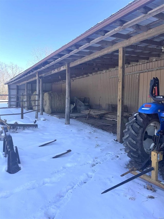 snow covered patio with an outbuilding and a pole building