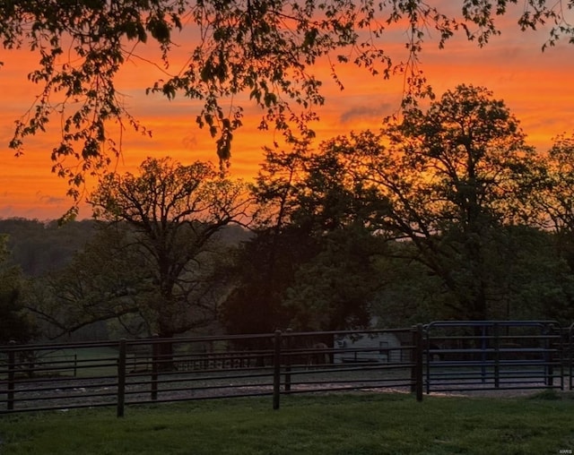 yard at dusk featuring a gate and fence