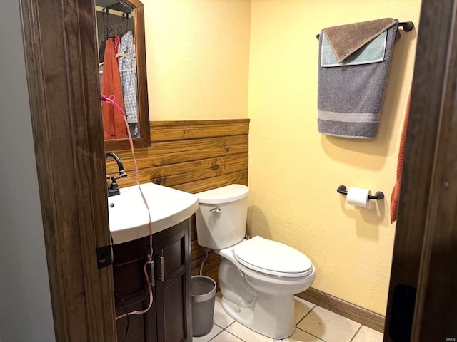 half bathroom with tile patterned floors, toilet, and vanity