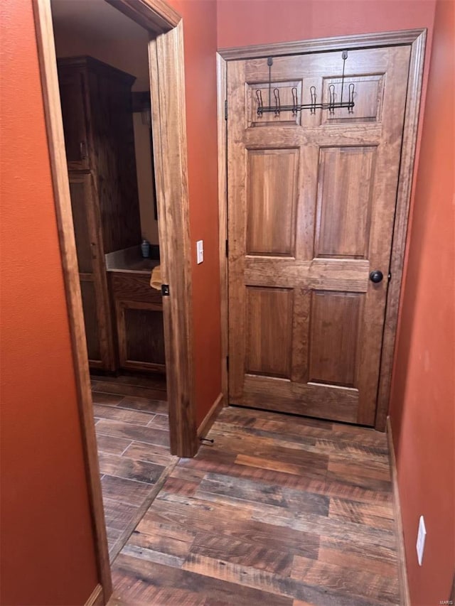 corridor with wood finished floors and baseboards