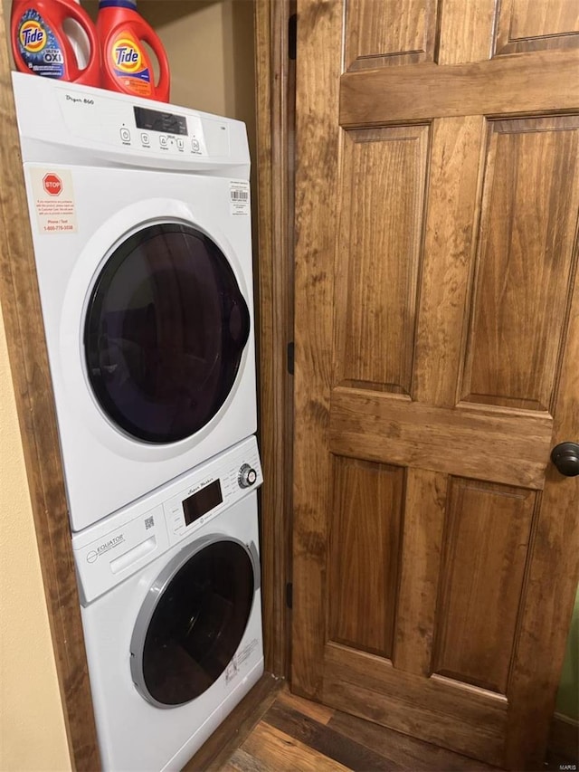 washroom featuring laundry area, stacked washer and clothes dryer, and wood finished floors