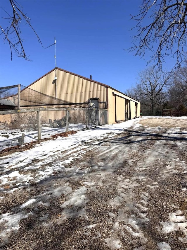 snow covered structure with fence