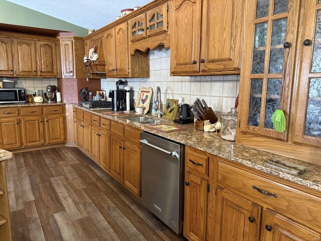 kitchen featuring dark wood-style floors, brown cabinetry, stainless steel appliances, and a sink