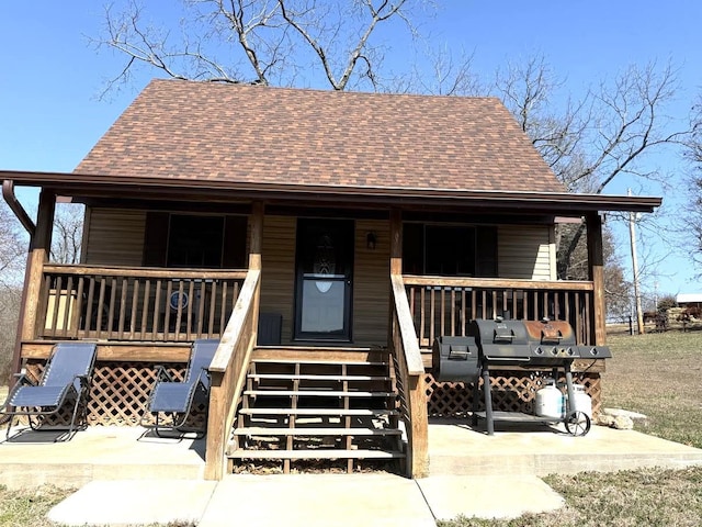 view of front facade featuring covered porch and roof with shingles