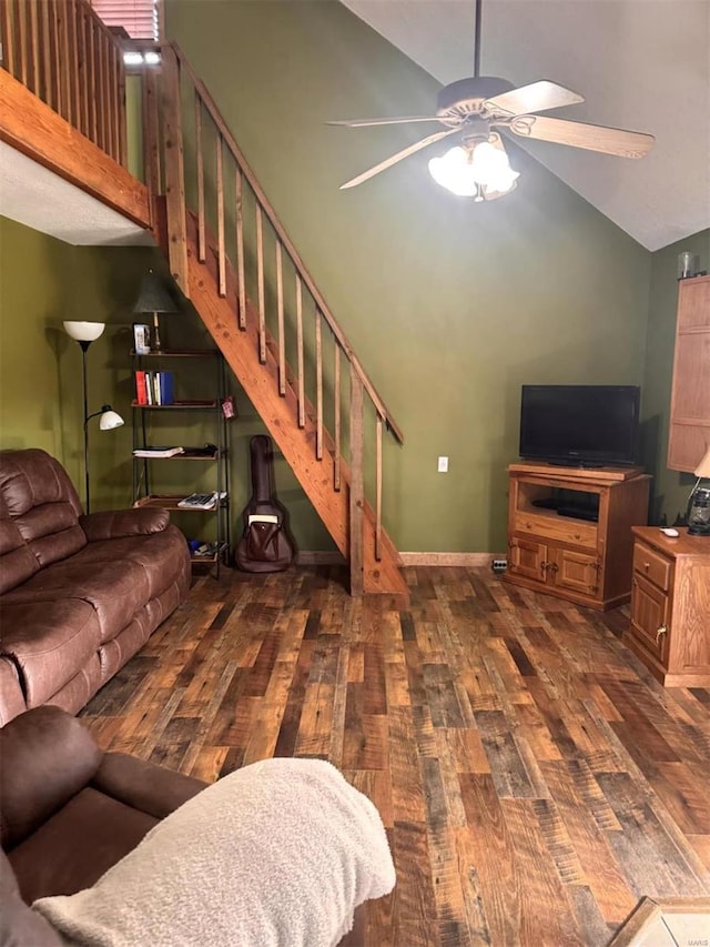 living room featuring ceiling fan, wood finished floors, stairs, baseboards, and lofted ceiling