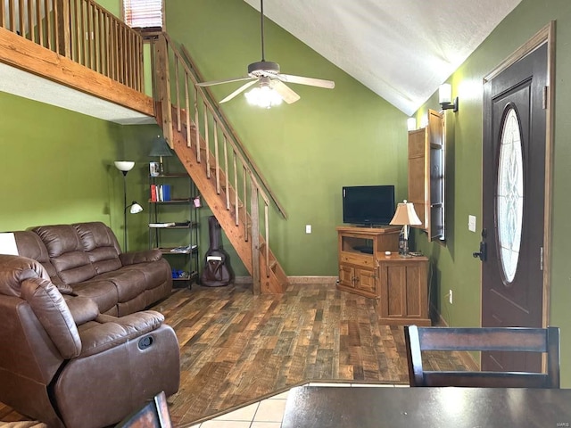 living area with a ceiling fan, stairway, wood finished floors, and lofted ceiling