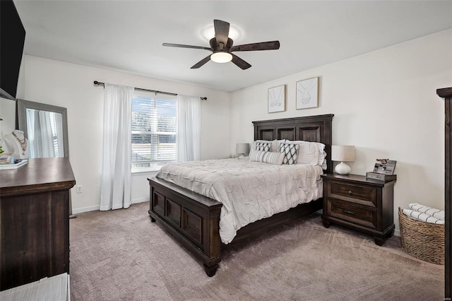 bedroom featuring baseboards, light carpet, and a ceiling fan