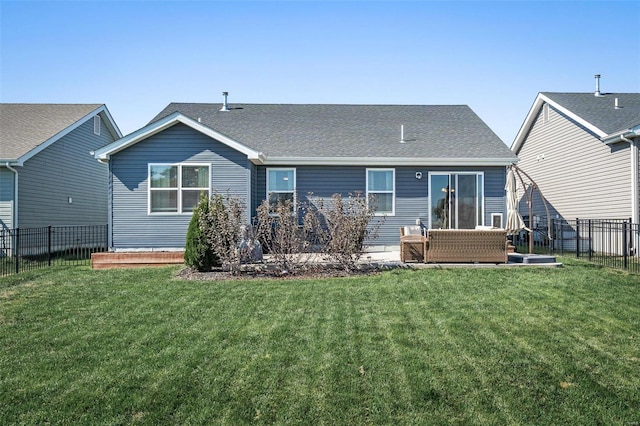 rear view of property featuring a yard, roof with shingles, and a fenced backyard